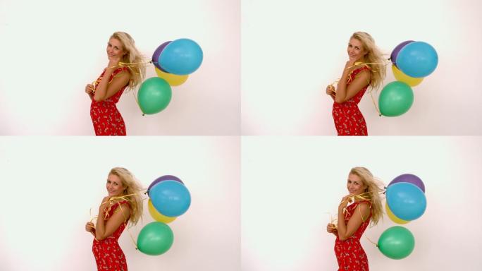 一个女人拿着彩色气球微笑特写