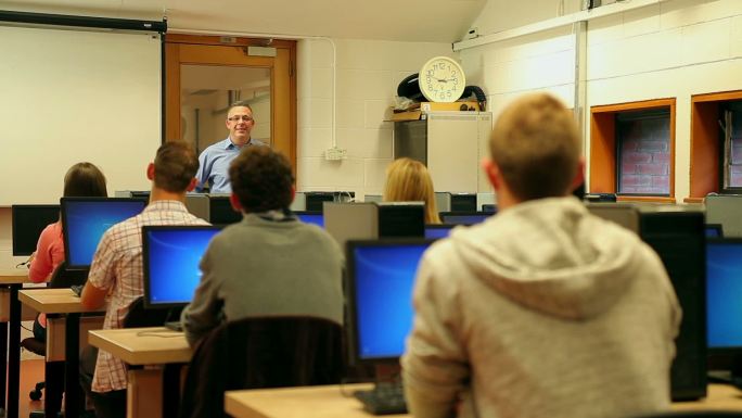 学生们在大学的电脑室里听讲师讲课