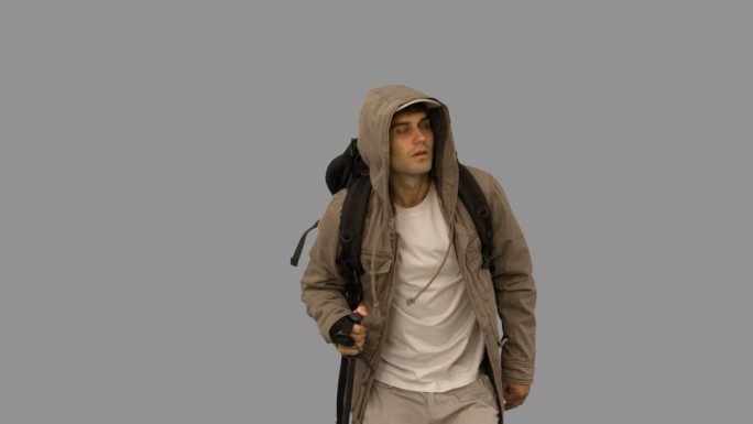 一个穿着大衣的帅哥在灰色屏幕上慢动作地徒步旅行