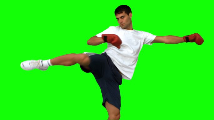 绿色背景下男人戴着拳击手套打拳特写