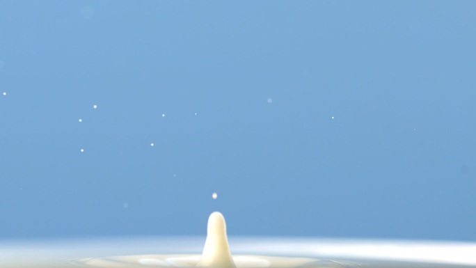 白色的水滴滴落在水中特写