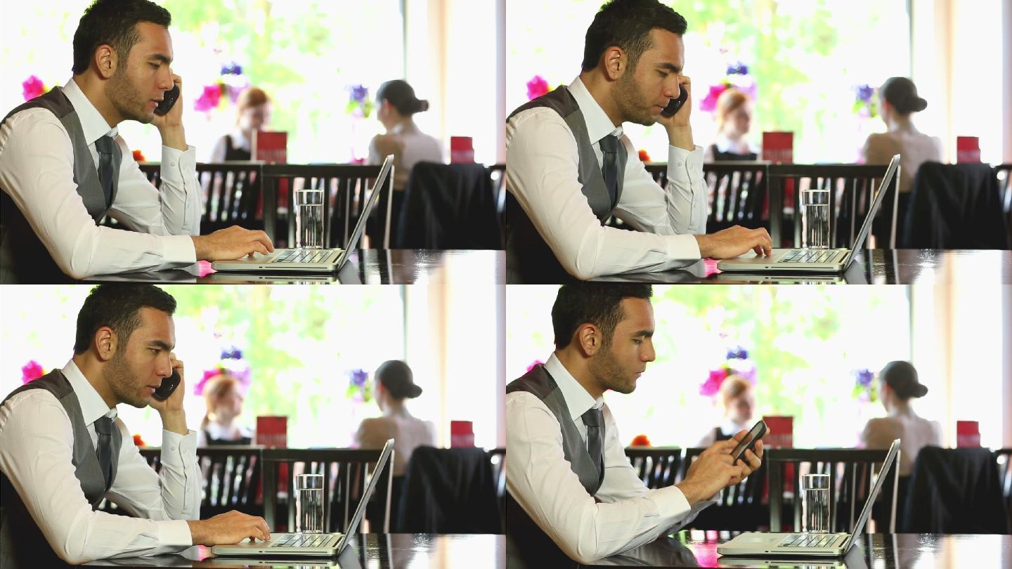 帅气的商人在高档餐厅里用笔记本电脑工作