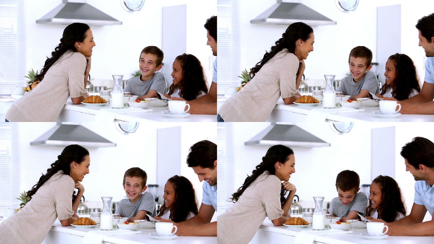 母亲在厨房里与孩子们在家庭早餐时聊天