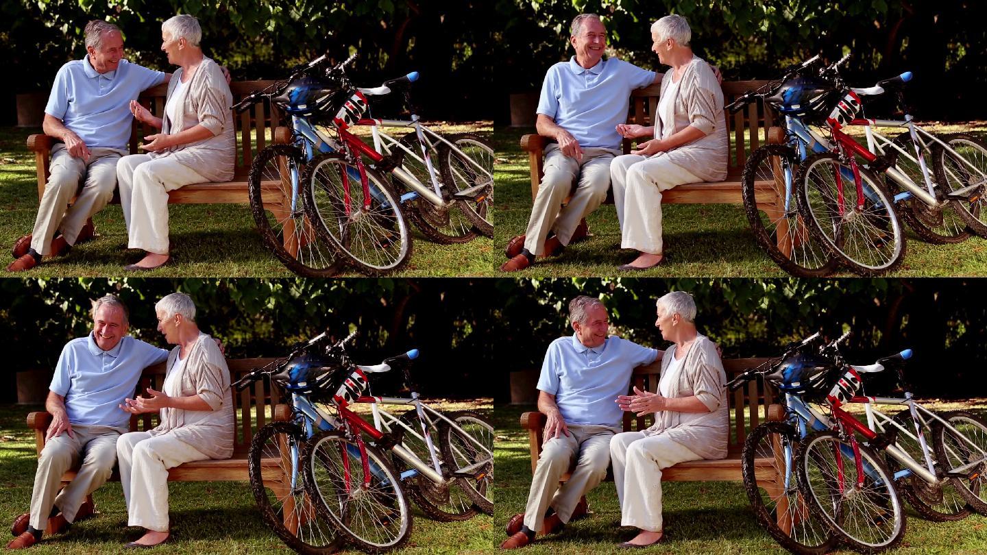 一对老夫妇坐在公园的长椅上聊天特写