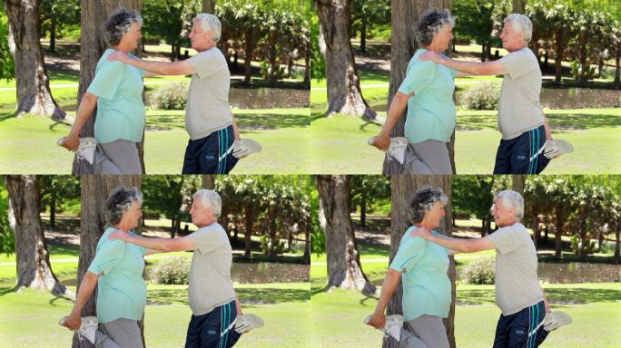 一对退休夫妇在公园里做伸展运动特写