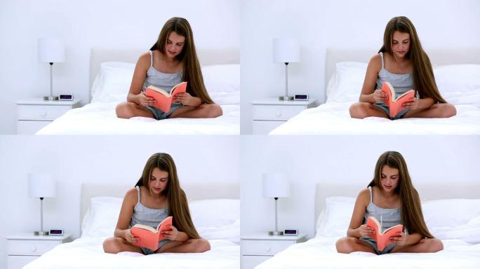 可爱的女孩在卧室的床上看书