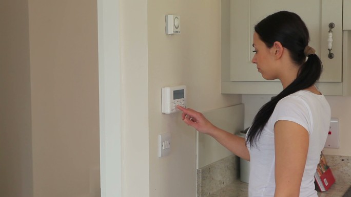 一个女人打开了厨房的警报系统