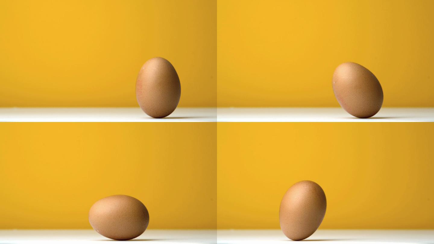 鸡蛋在黄色背景下翻滚特写