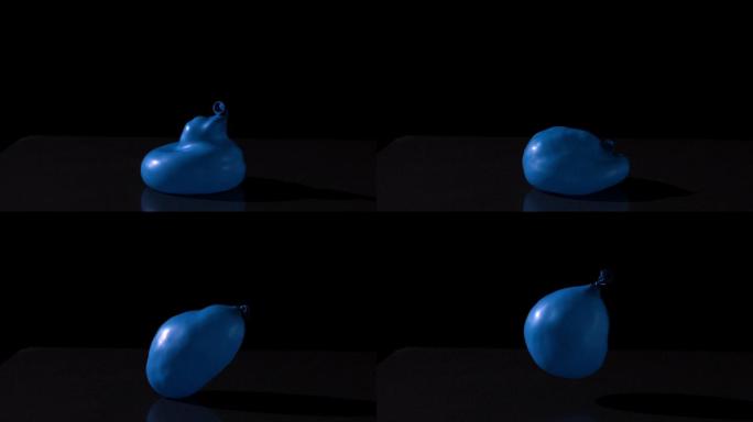 蓝色水球落在黑色背景上的慢动作