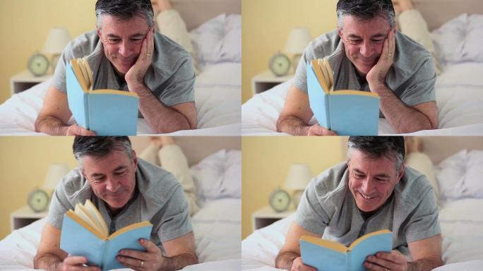 一个成熟的男人躺在床上在卧室里看书