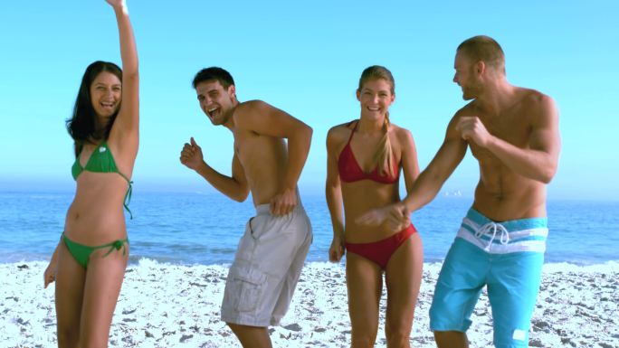 一群朋友在海滩上慢镜头跳舞