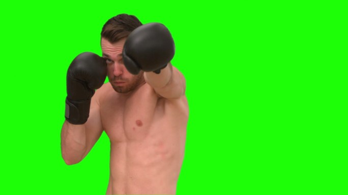 绿色背景下男人戴着拳击手套打拳特写