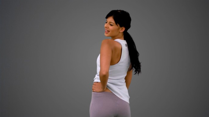 女人穿着运动服在灰色背景下锻炼特写