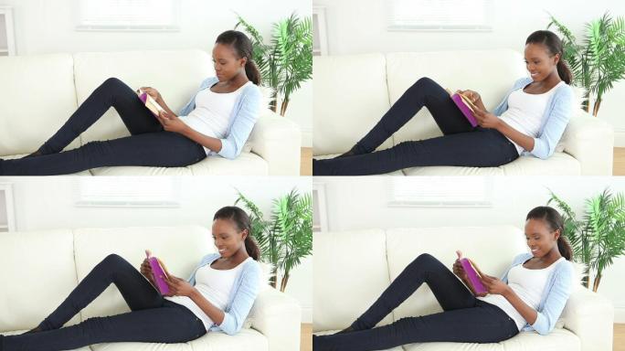 一名黑人妇女在客厅拿着一本书的视频