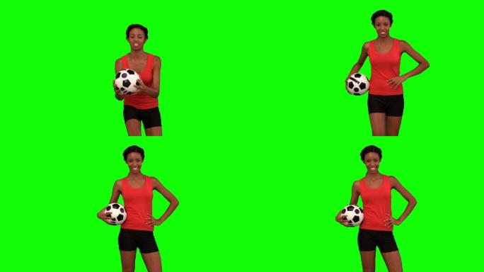 绿色背景下女人抱着足球特写