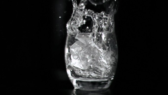 冰块掉落在一杯水里特写