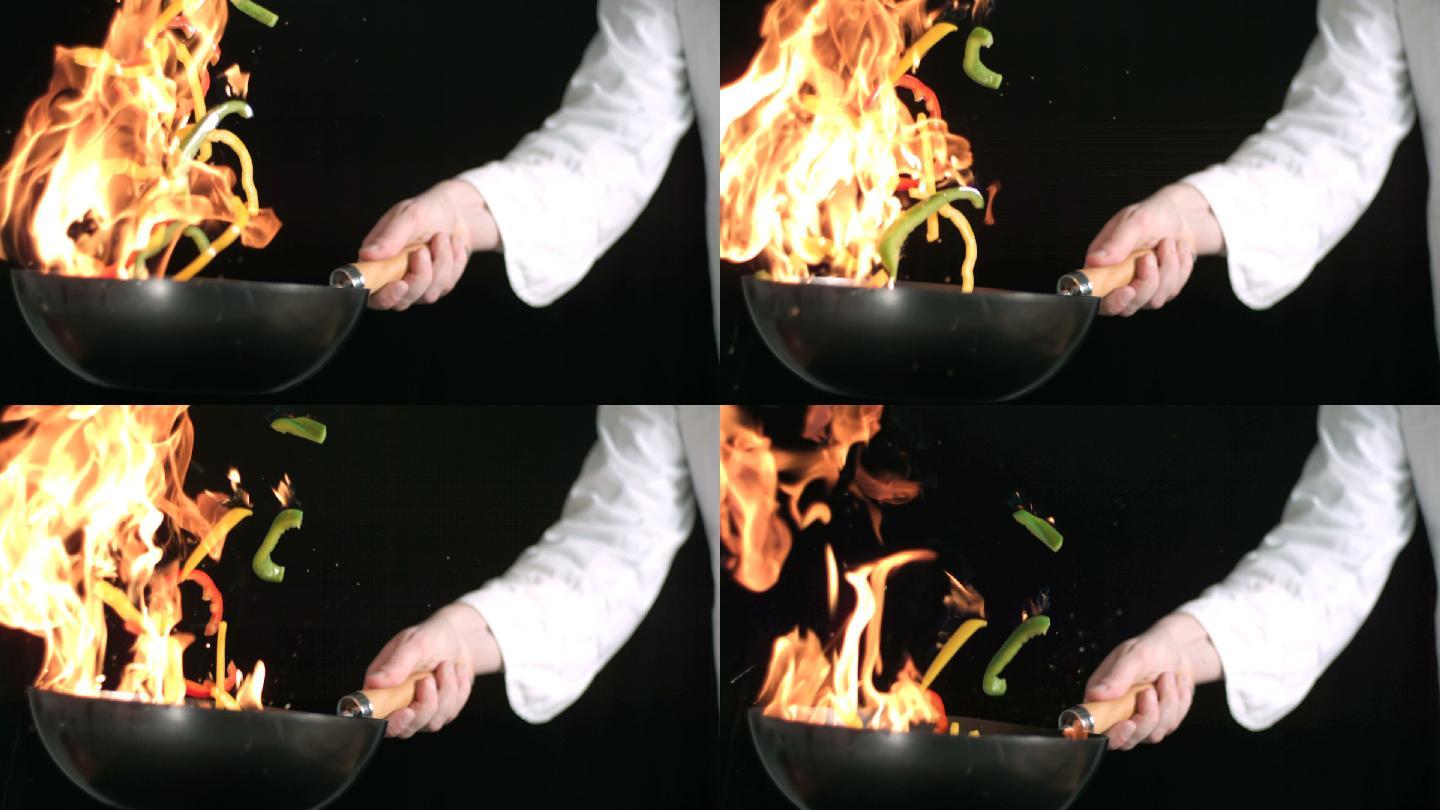 厨师在烧红的炒锅中用慢动作翻炒