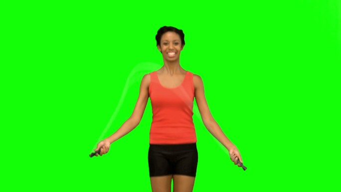 女人在绿色背景下跳绳锻炼特写