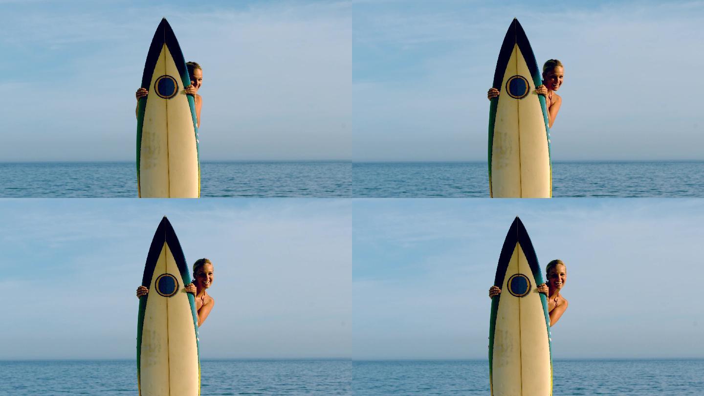 女人拿着冲浪板站在海边特写