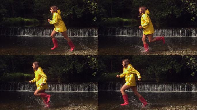 穿着黄色雨衣的女人在瀑布前流过水