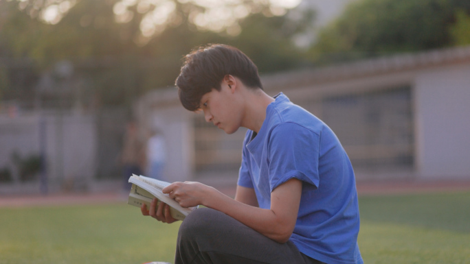 户外夕阳操场草坪看书