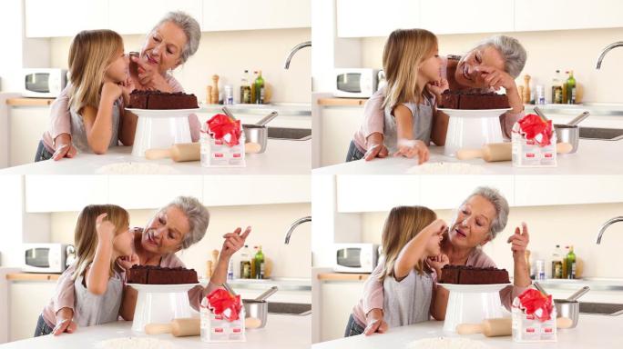 奶奶在厨房里开玩笑地往女儿的鼻子上抹糖霜