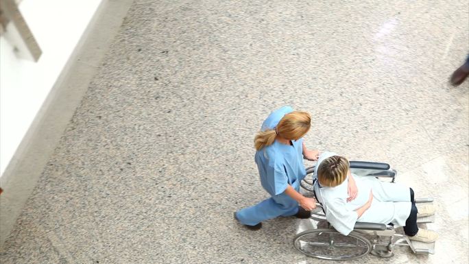 医疗团队用轮椅推着女人在医院里特写