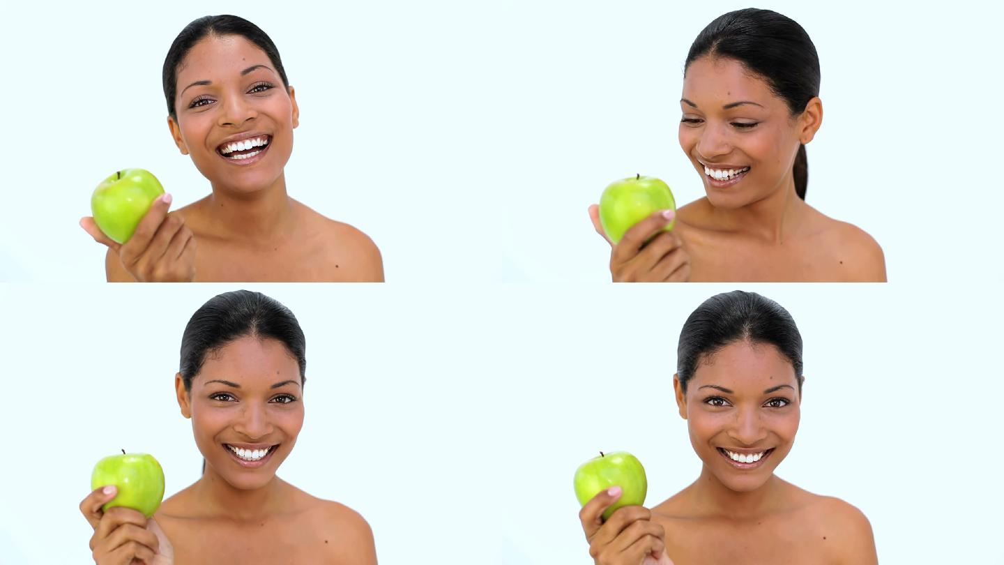 一个女人拿着苹果微笑特写