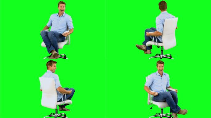 绿色背景下男人坐在椅子上大笑特写