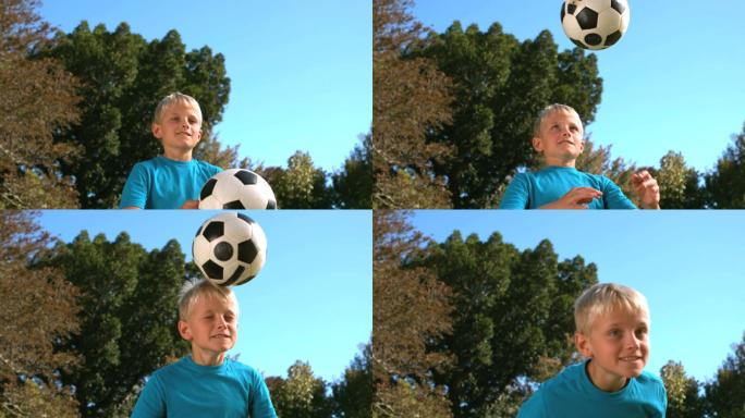 一个小男孩用慢镜头顶着一个足球