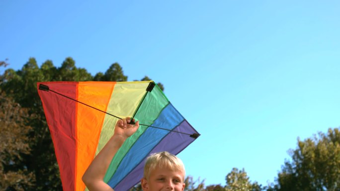 一个小男孩拿着风筝在慢镜头中奔跑