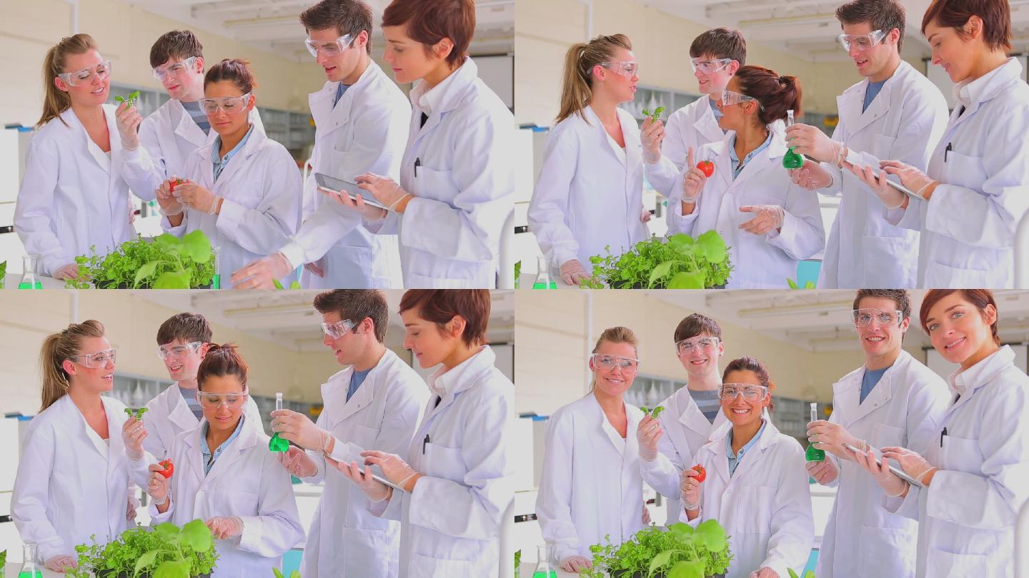生物学学生站在实验室里，手里拿着番茄和平板电脑