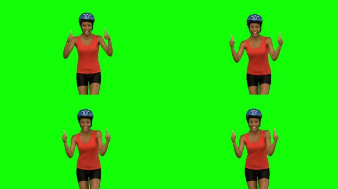 女人戴着自行车头盔对镜头竖起大拇指特写