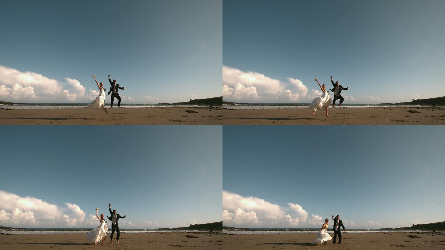 一对快乐的新婚夫妇在沙滩上用慢镜头跳来跳去