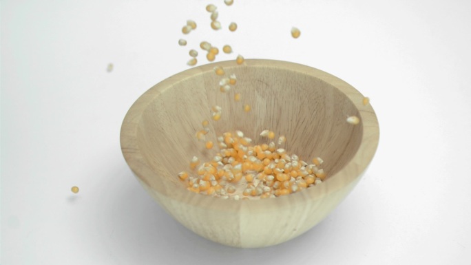 玉米粒掉进木制碗里特写