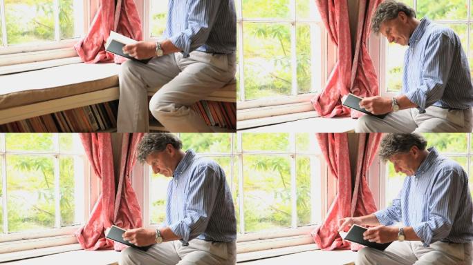 一个成熟的男人坐在客厅的窗边看书