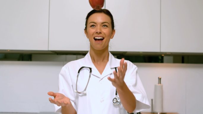 护士在厨房向上扔苹果特写