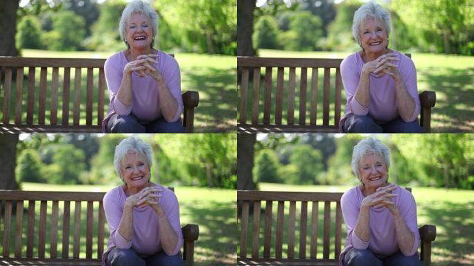 退休妇女微笑着坐在公园的长椅上特写