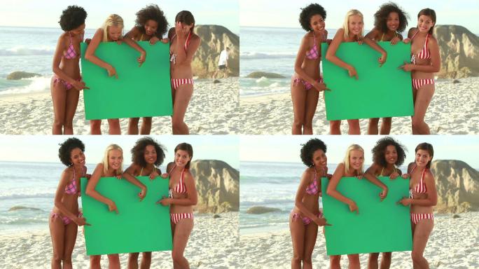 朋友们在沙滩上抱着绿色板子特写