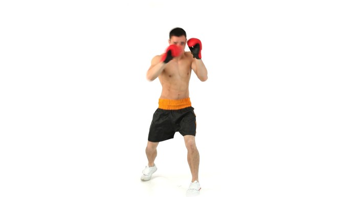 戴着手套在白色背景下拳击的运动员特写