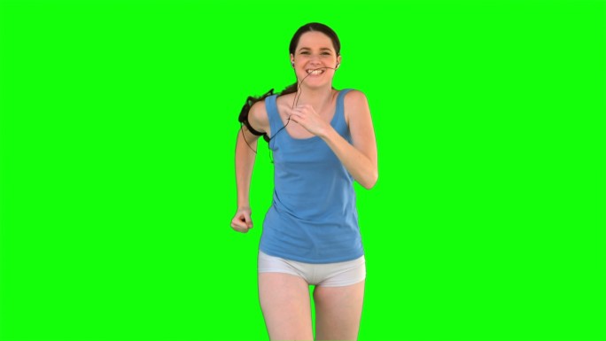 女人穿着运动服在绿色背景下跑步特写