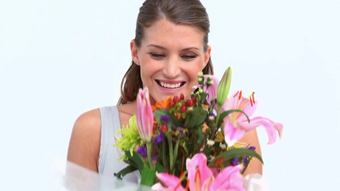 女人在白色背景下拿着花束微笑特写