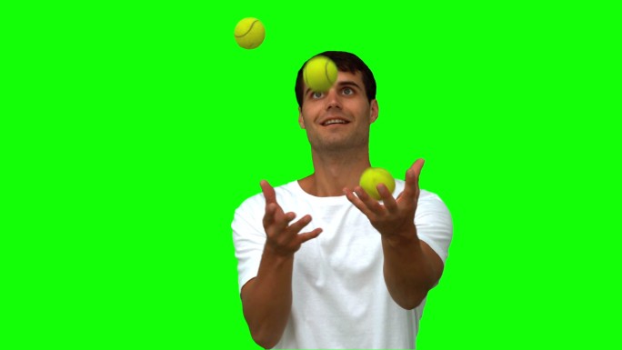 绿色背景下男人抛起网球特写