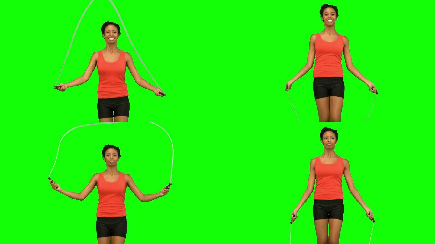 女人在绿色背景下跳绳锻炼特写