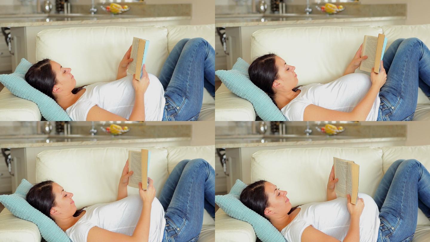 一个孕妇在客厅的沙发上看书
