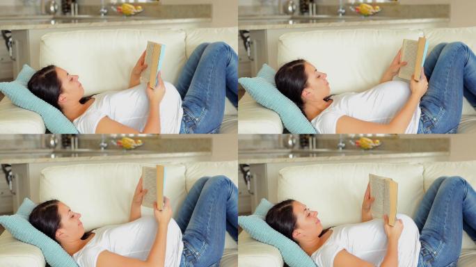 一个孕妇在客厅的沙发上看书