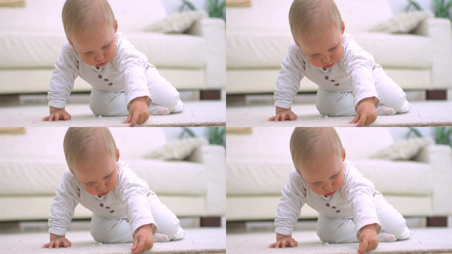 婴儿触摸着白色的地毯特写
