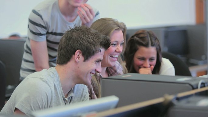 学生们在电脑室里一起坐着、笑着