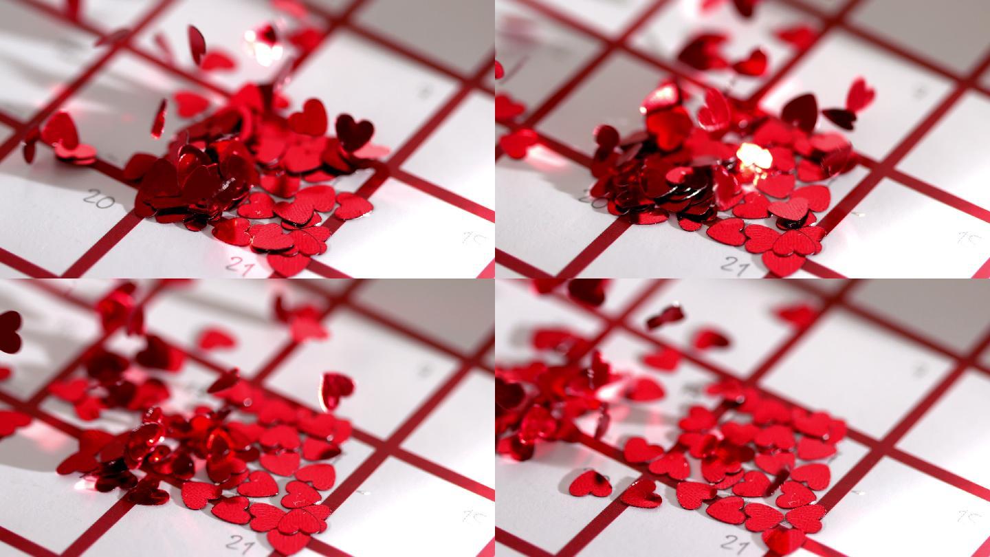 红色心形碎花飘落到日历上特写