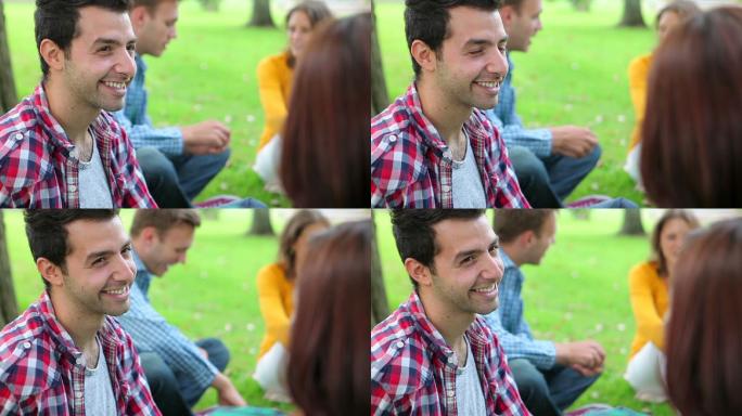 微笑的学生在大学校园的草地上聊天